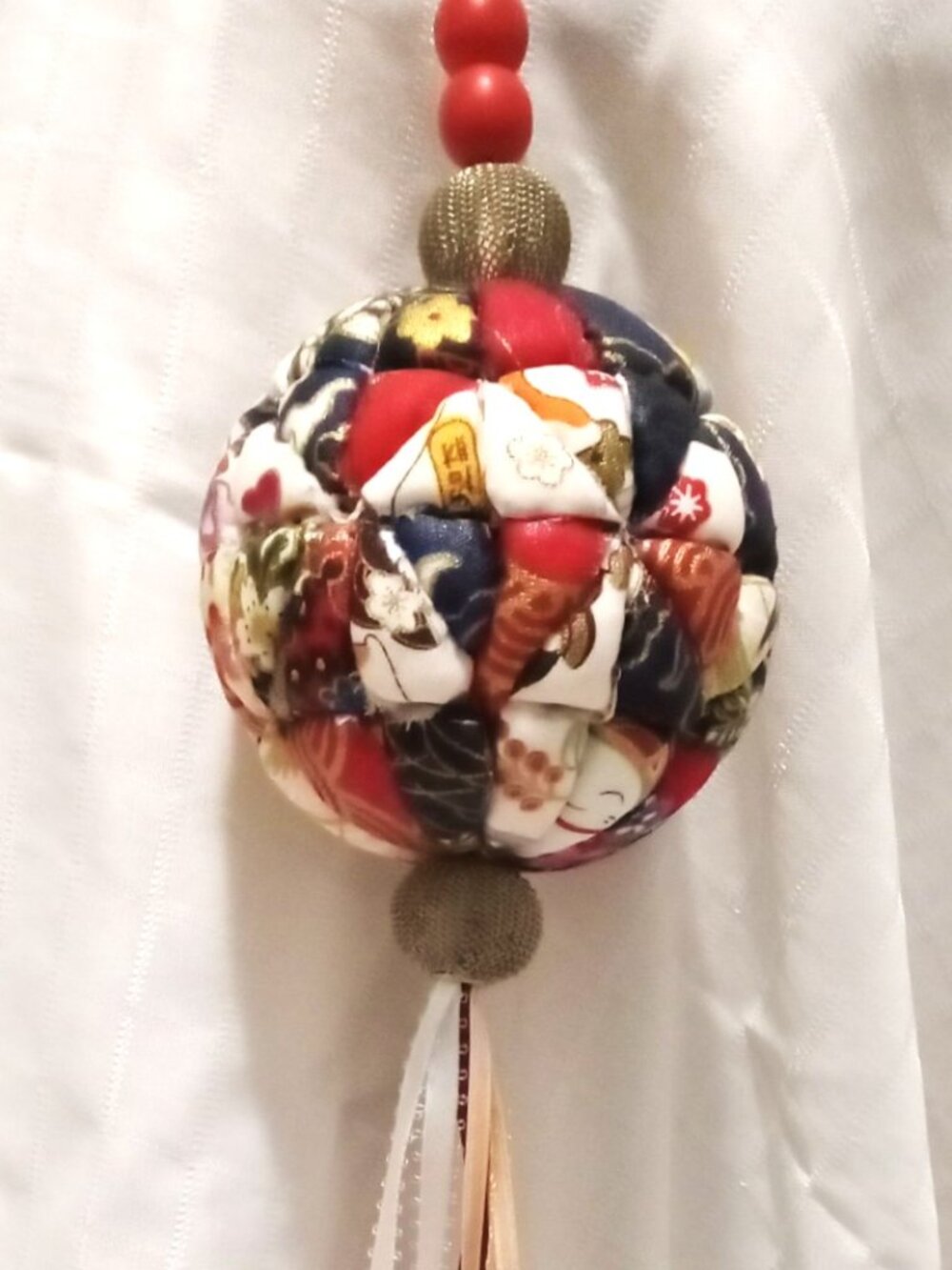Handmade hanging decoration made with a foam ball and fabric with gold threads